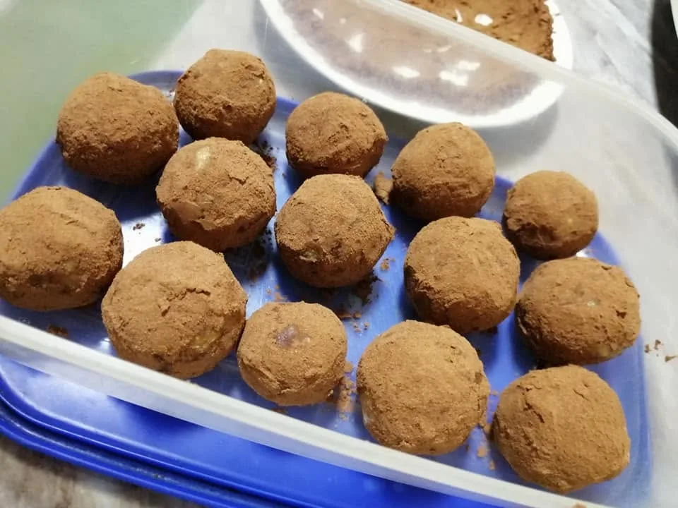 Kuglice posute kakaom na plavoj podlozi.